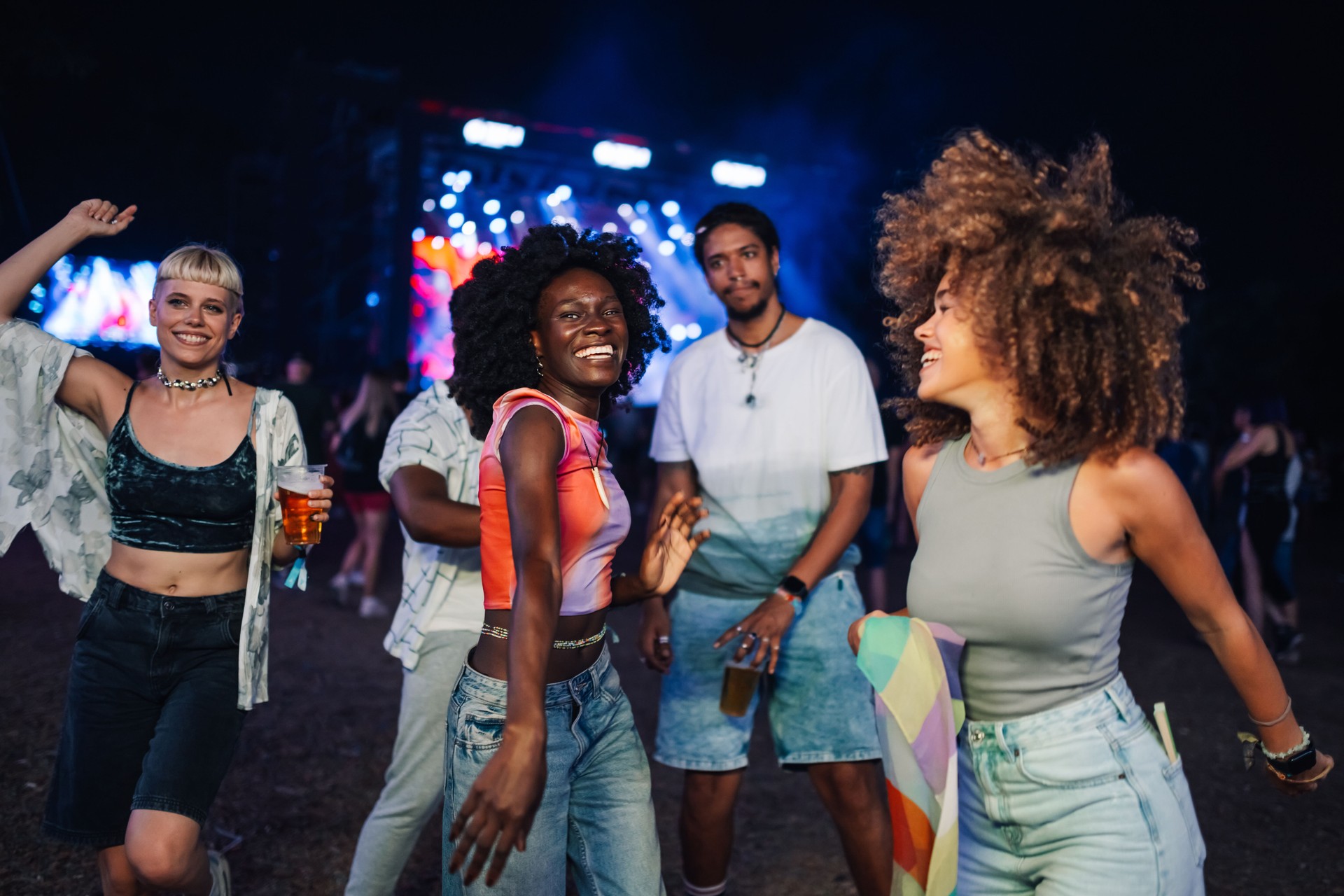 Friends dancing and enjoying music festival at night